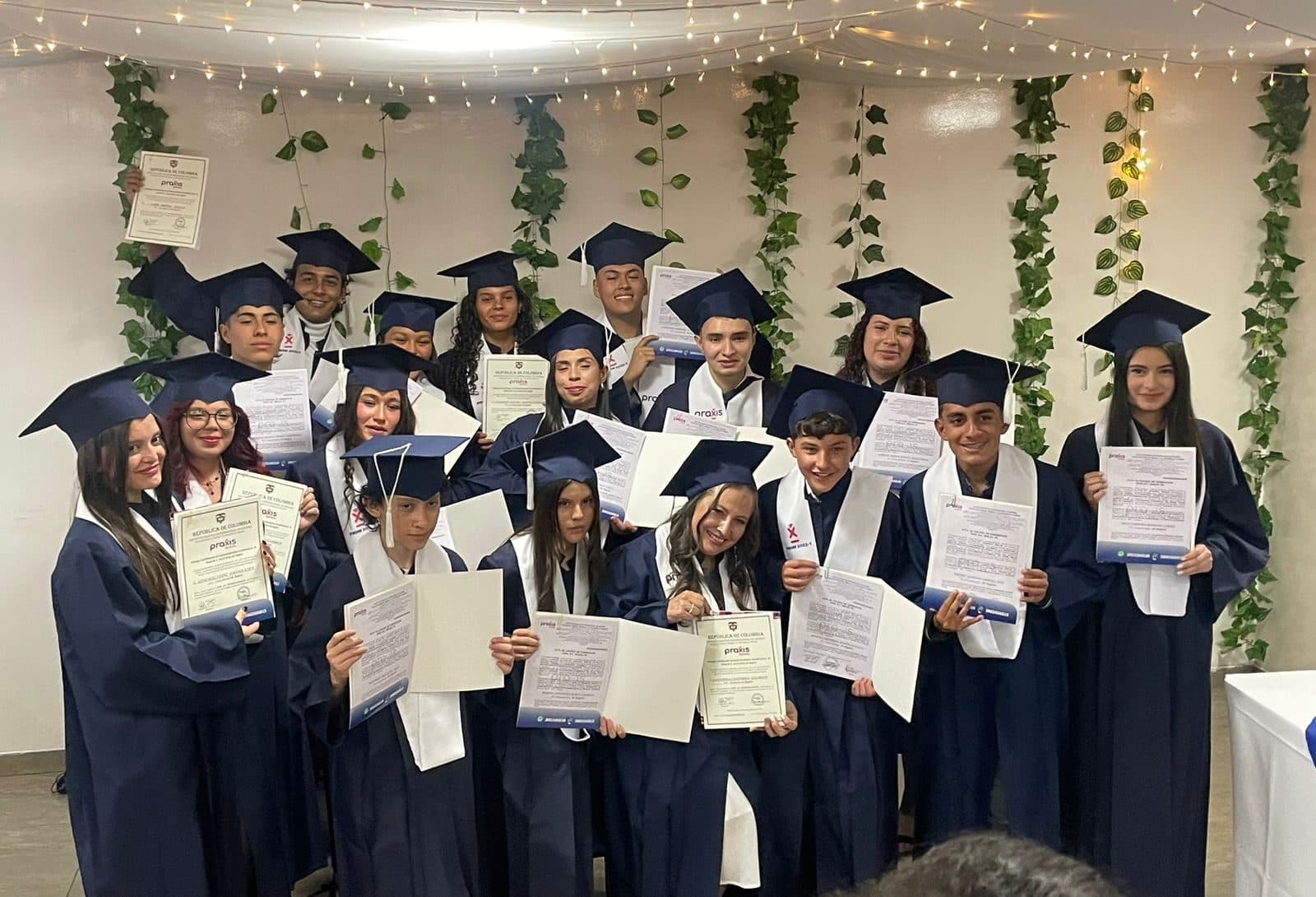 Graduados del curso de inglés de Praxis School con birrete y diploma